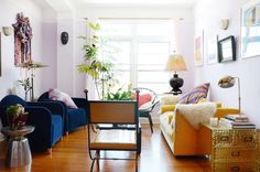 a living room filled with lots of furniture and decor on top of hard wood floors