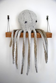 an octopus sculpture hanging from a wooden shelf