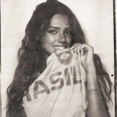 a black and white photo of a woman with long hair wearing a tshirt