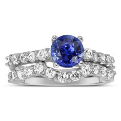 a blue sapphire and diamond ring set with matching wedding bands on top of each other