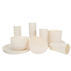 white dishes and cups are stacked on top of each other in front of a white background