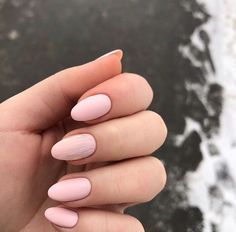 a woman's hand with pink and white manies on it, holding onto her fingers