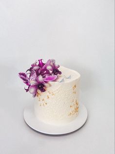 a white cake with purple flowers on top