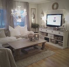 a living room filled with furniture and a flat screen tv mounted on a wall above a wooden coffee table