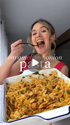 a woman is eating pasta from a casserole dish