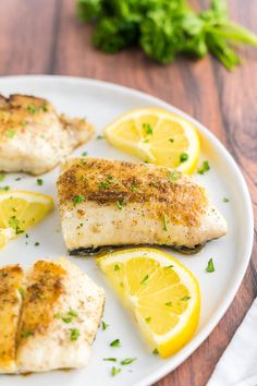 fish with lemon slices and parsley on a white plate