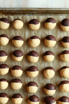 chocolate covered doughnuts on a baking sheet ready to be baked in the oven