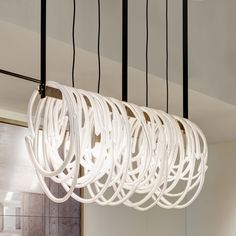 a dining room table and chairs under a chandelier with lights hanging from the ceiling