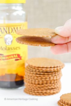 a hand holding a cracker over some cookies