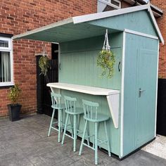 an outdoor bar with four stools in front of it