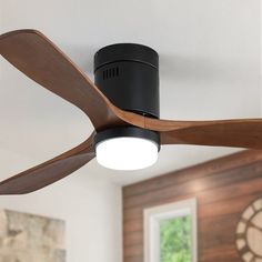 a black ceiling fan with wooden blades in a living room