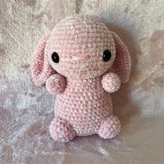 a pink stuffed animal sitting on top of a bed