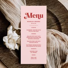 a pink menu card sitting on top of a plate