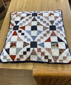 a table with a quilt on top of it and a wooden chair in the background