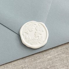 an envelope with a wax stamp on the front, and a blue envelope liner in the back