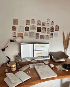 a desk with two computers and books on it