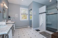 a bathroom with two sinks and a walk in shower