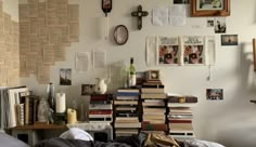 a room filled with lots of books and pictures on the wall next to a bed