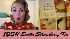 a woman holding a plate with strawberries in front of her face and an old recipe book behind her