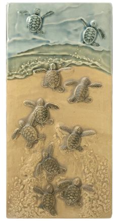 four turtles swimming in the ocean on sand