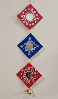 three different colored ornaments hanging on the wall