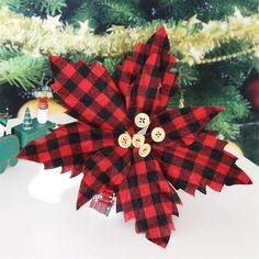 a red and black plaid poinsettia sitting on top of a table