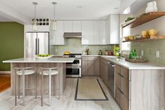 a kitchen with white cabinets and wooden floors