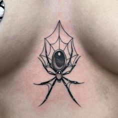 a spider tattoo on the back of a woman's chest