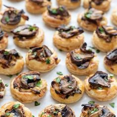 small pastries with mushrooms on them sitting on a table