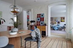 a dining room table and chairs in front of an open door to the living room