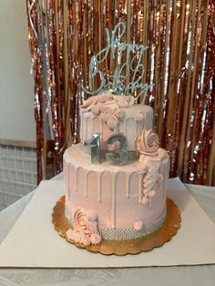 a three tiered cake decorated with pink icing