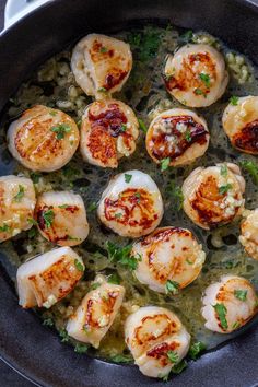 some scallops are cooking in a skillet on top of the stove and garnished with parsley