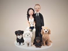 a wedding cake topper with two dogs and a bride in a tuxedo