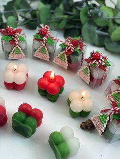 small candles are arranged on a table with christmas decorations