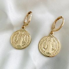 A pair of dainty gold St. Benedict coin earrings. These lightweight huggie hoops work as a protection amulet against all evil and make the perfect gift for you or your loved ones!  ITEM DESCRIPTION  Gold Coin Earrings Material: - Gold Filled -Coin Width: 18mm  - Hoop Diameter: 11mm  BENEFITS -Hypoallergenic -Water Resistant -Tarnish Resistant -Perfect for all time. -High-quality Earrings! JEWELRY CARE: - All our garments will be accompanied by care instructions, a bag to store them when you are Gold Dangle Huggie Earrings Nickel Free, Gold Coin Earrings, St Benedict Medal, Benedict Medal, St Benedict, Protection Amulet, Saint Benedict, Gold Filled Hoops, Coin Earrings