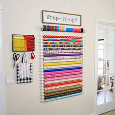 a wall hanging on the side of a room filled with different types of fabric