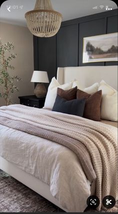 a bedroom with a bed, lamps and pictures on the wall