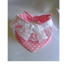 a pink and white polka dot bib with lace on the front, bow tie at the back