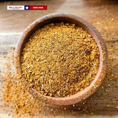 a wooden bowl filled with ground mustard on top of a table