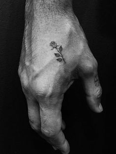 a small rose tattoo on the left hand