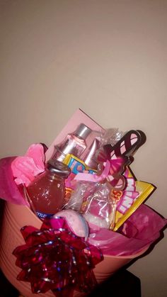 a pink bucket filled with assorted items on top of a table