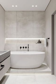 a large white bath tub sitting next to a sink in a bathroom under two mirrors