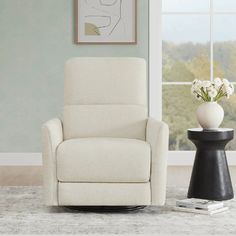 a living room with a white chair and black table in front of a large window