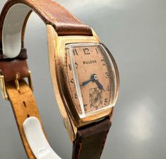 Rare 1940s original BULOVA CURVEX TANK with brand new brown saddle leather strap and with a very well preserved Curvex glass, with sought-after, salmon-colored original dial with black, Arabic indexes and original, blued steel pointers. Original legendary BULOVA caliber 10BC with 15 jewels, watch runs perfectly for it's age. Worth collecting, original timeless classic in good condition! Vintage Watches With Leather Strap And Rectangular Dial, Vintage Watch With Leather Strap And Rectangular Dial, Vintage Brown Leather Watches, Vintage Leather Watch With Chronometer, Antique Brown Analog Watch, Vintage Brown Leather Watch, Vintage Watches With Leather Strap, Vintage Leather Watches For Business, Vintage Brown Watches With Leather Strap