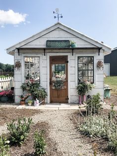 a small white building with potted plants outside