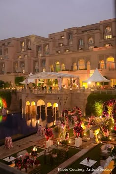 an outdoor event with tables and chairs set up in front of a building at night