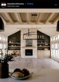 a large open living room with fireplace and built in shelves