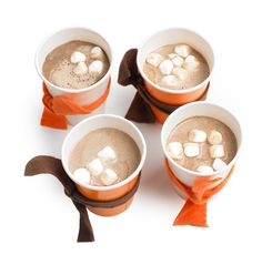 four cups filled with hot chocolate and marshmallows