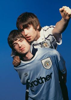 two young men hugging each other in front of a blue sky