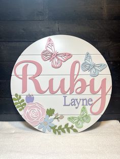 "Name Sign, Nursery Name Sign, Floral Name Sign, Floral and Butterfly Sign, Flowers and Butterflies, Round Name Sign, Custom Name Sign, Signs This custom name sign is handmade. It features a 3D design and it is the perfect addition for a nursery, kids room, or play room.  This sign also makes a great gift for a baby shower, birthday, holiday, or any other special occasion! Each piece is unique and one-of-a-kind, from the selection of the wood, the preparation process, to the design and the finis Rainbow Name Sign, Painted Name Signs, Flamingo Nursery Decor, Custom Nursery Sign, Nursery Room Themes, Kids Room Sign, Floral Signs, Wood Name Sign, Flower Nursery